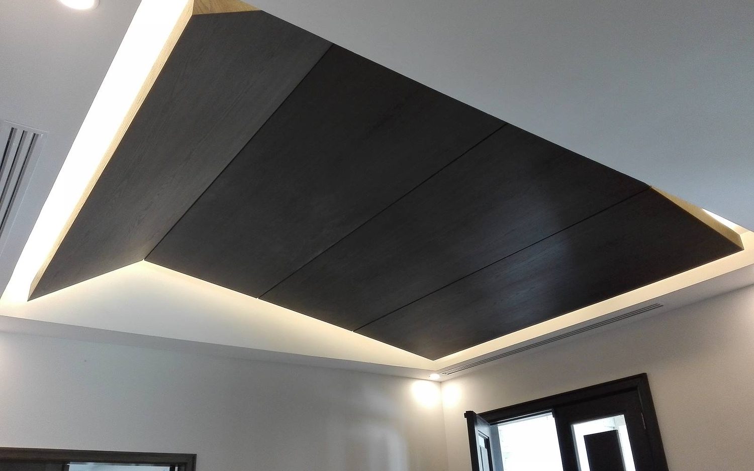 Plafón de madera oscura con iluminación indirecta